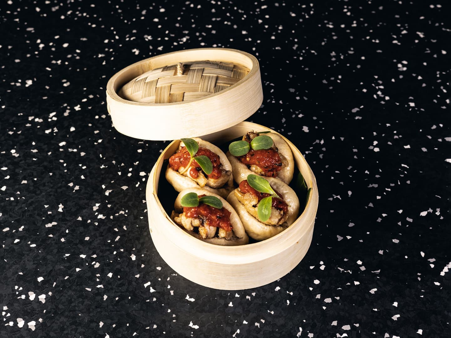 <p>Steamed bao bun, boneless chicken wings, tomato salsa and garden cress</p>