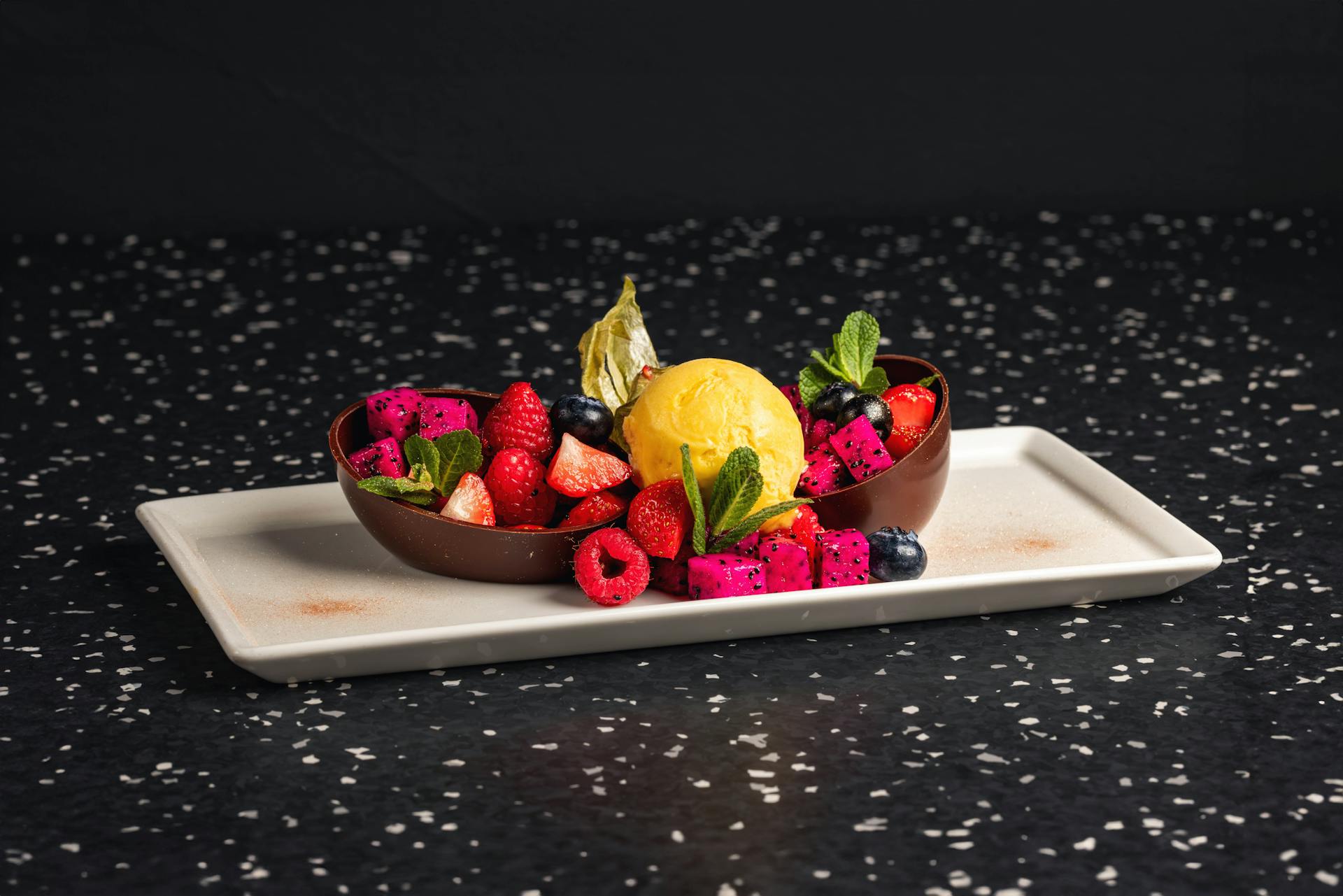 <p>Exotic fruit salad served in chocolate shell and sorbet</p>