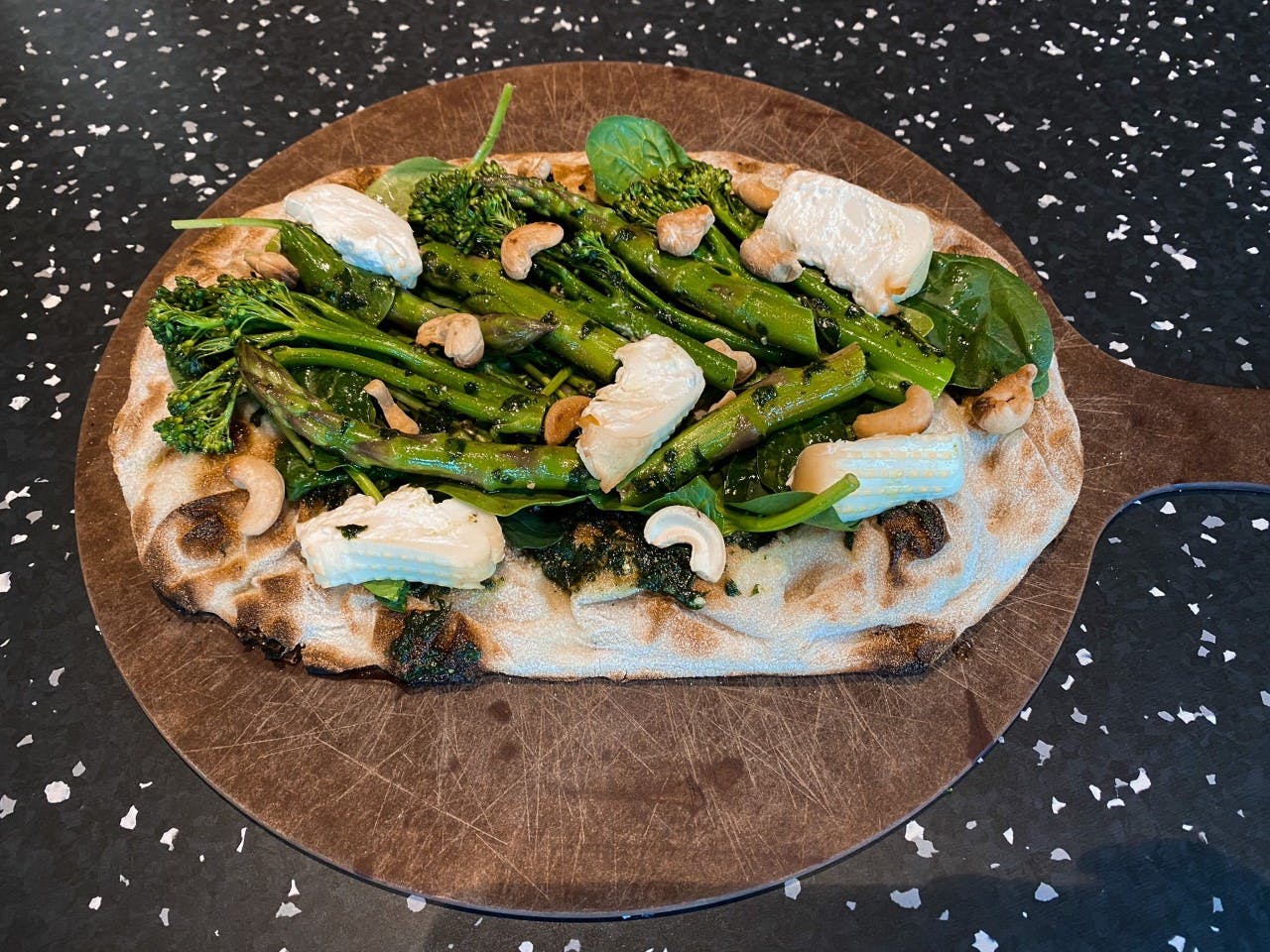 <p>Green vegetable Pinsa with smoked Burrata and roasted cashews</p>