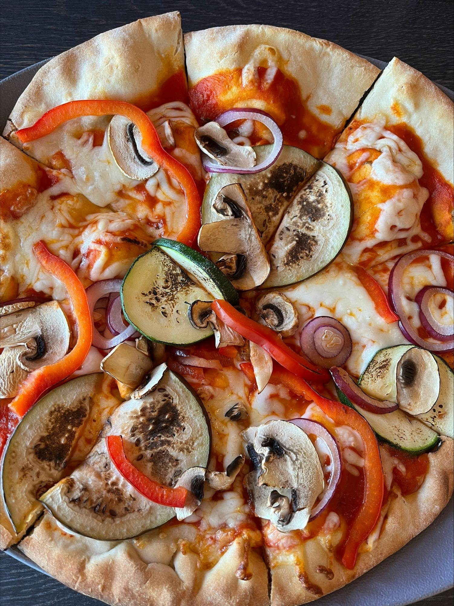 <p>Pizza dough with tomato sauce, eggplant and mushrooms</p>